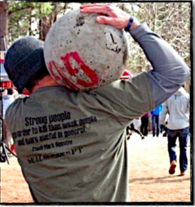 Man holding an atlas stone on his shoulder displaying functional fitness